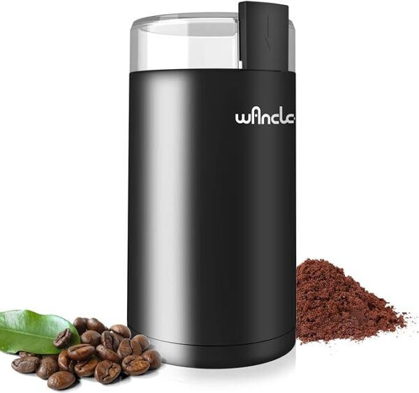Electric coffee grinder with coffee beans and grounds.